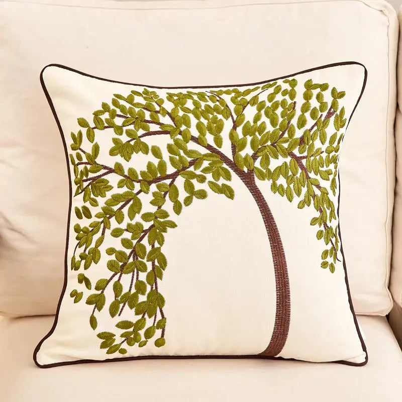 Cream-colored embroidered cushion cover with an olive green tree and dark brown piping for living room sofa
