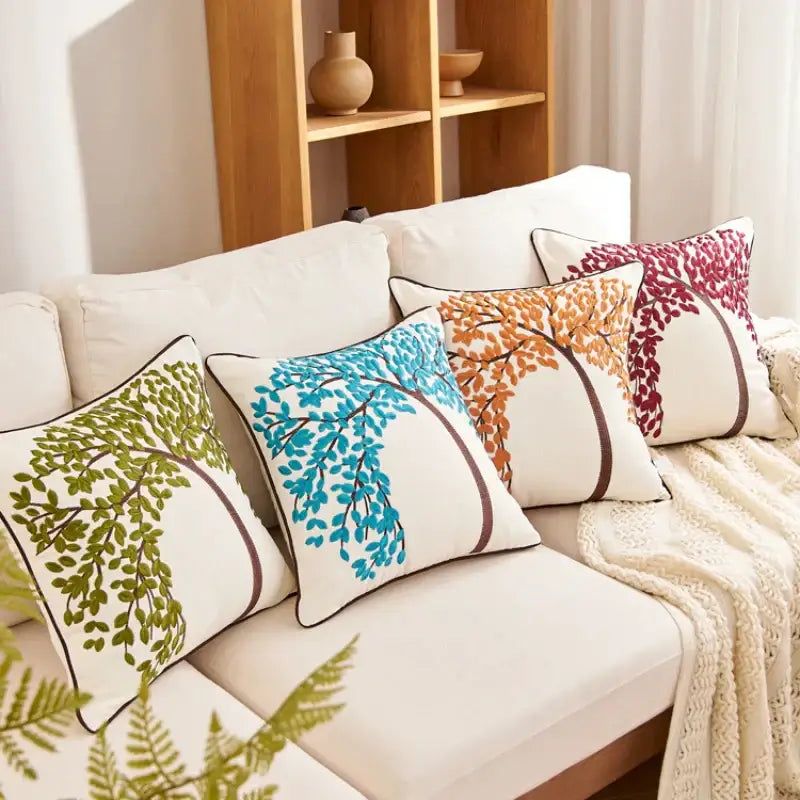 Embroidered cushion cover set with tree patterns in green blue orange and maroon on cream background with brown trim