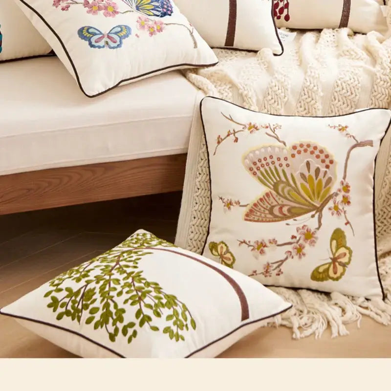 White embroidered cushion cover with butterfly and floral branches in green brown and pink for living room sofa