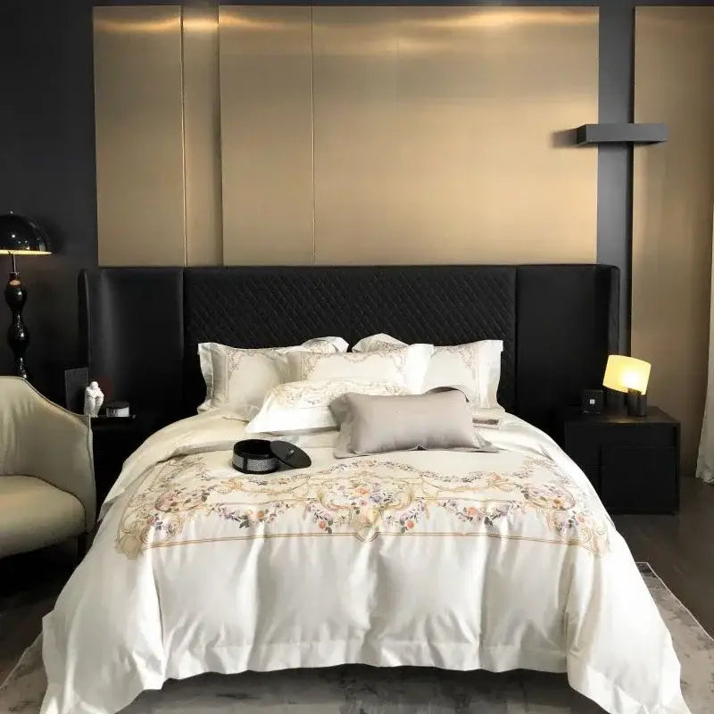 Embroidered white egyptian cotton bedding set featuring a satin duvet cover with floral embroidery and quilted black headboard