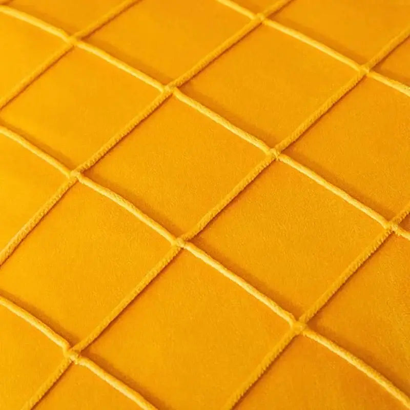 Vibrant yellow quilted fabric with diamond pattern on the back of emerald and burgundy decorbites corduroy striped pompom pillowcase