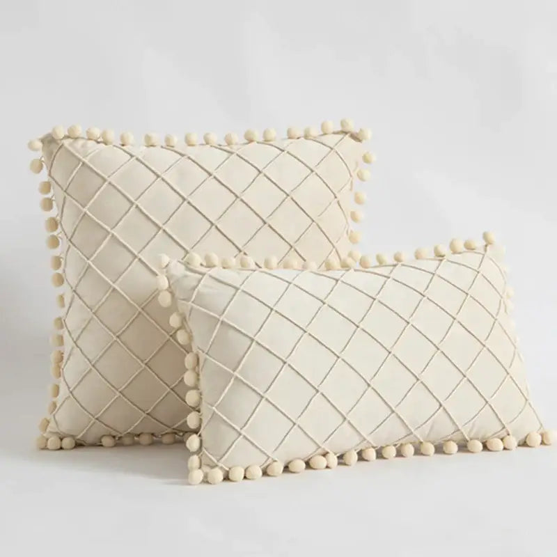 Cream-colored velvet throw pillows with diamond-quilted pattern and fluffy pom-pom trim for decorbites corduroy striped pompom pillowcase