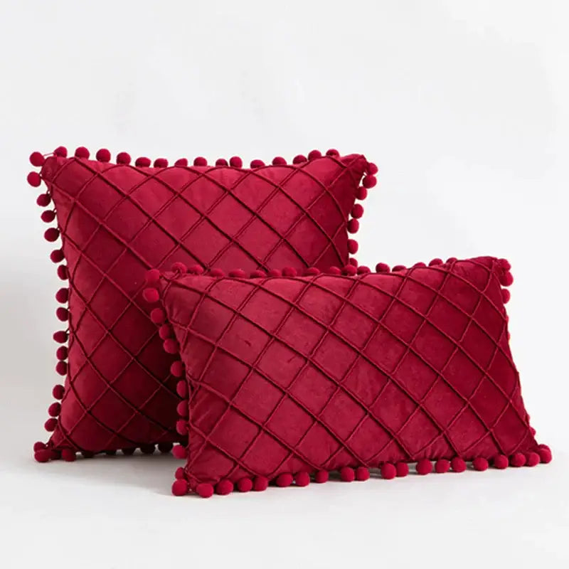 Deep red velvet throw pillows with diamond-quilted pattern and pom-pom trim in decorbites corduroy striped pompom style