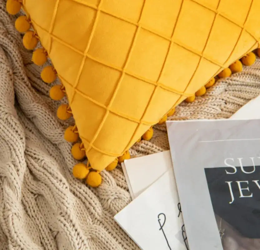 A vibrant yellow quilted corduroy striped pompom pillowcase with matching pom poms for living room decorbites decor