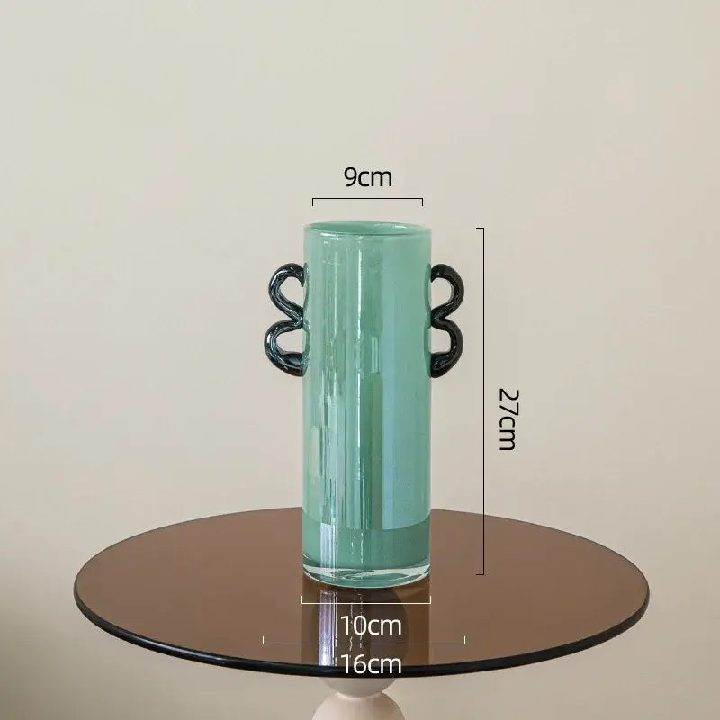 Emerald green glass vase with sleek black looped handles in translucent mint-green for living room decor