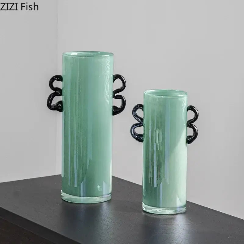 Two emerald green glass vases with black twisted handles for elegant living room decor accents