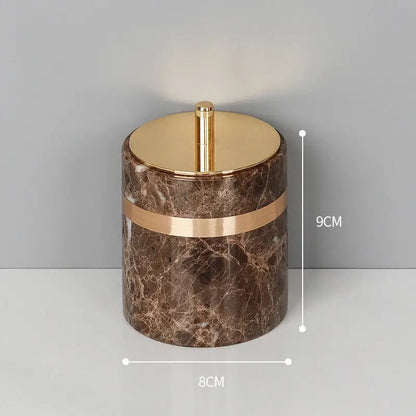 Brown emperador dark marble cylindrical container with gold-toned lid and accent band for dark marble bathroom use