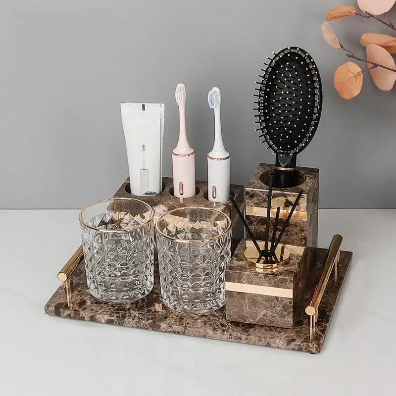 Elegant emperador dark marble bathroom set with gold accessories featuring textured glass cups and essential oil diffuser