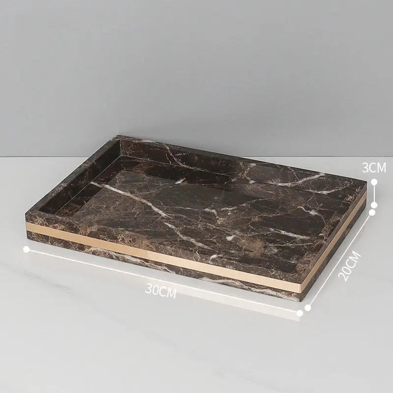 A sleek rectangular tray with emperador dark marble surface and gold trim for dark marble bathroom accessories