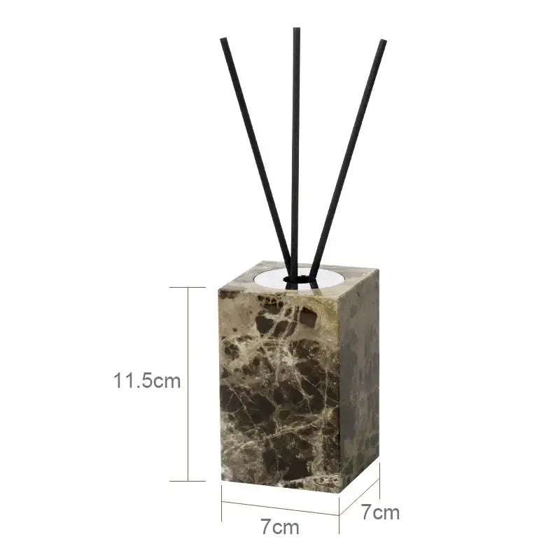 A sleek emperador dark marble reed diffuser with a square design and chrome accents holds four black reeds