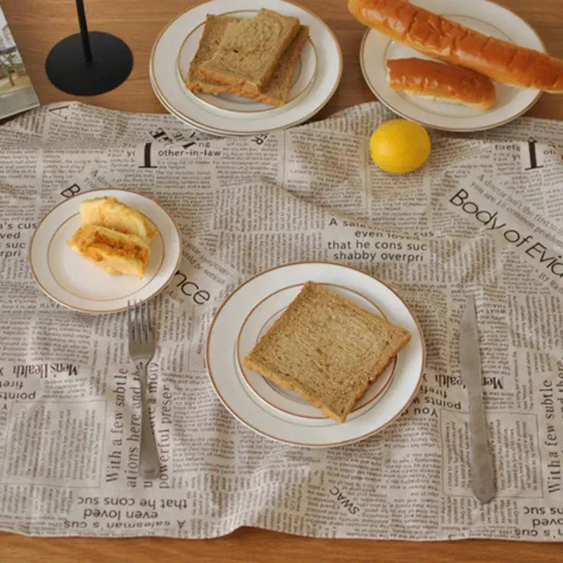 White ceramic plates with gold rims holding toasted bread on an english newspaper style photography props kitchen placemat