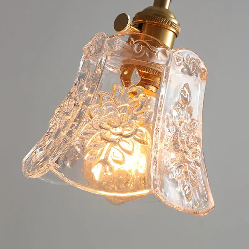 Etched glass pendant light with intricate floral etchings and polished copper fixture for dining room lighting