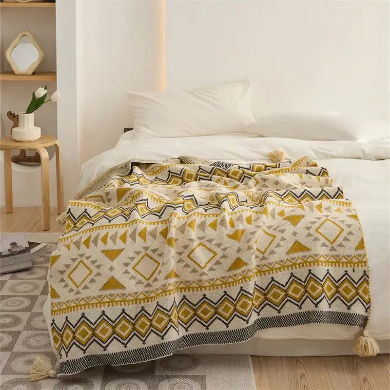 Cozy cream knit ethnic bohemian blanket with bold mustard yellow and black geometric patterns and tassels by decorbites