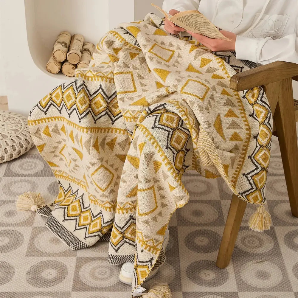 A decorbites ethnic bohemian cream and mustard knit throw blanket with geometric pattern and tassels for living room decor