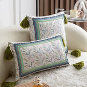Two rectangular pillow covers with ethnic botanical print and olive green tassels in teal and navy cover set