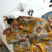 Ethnic cotton blanket by decorbites featuring warm mustard yellow quilt with navy paisley and floral patterns for bedroom decor