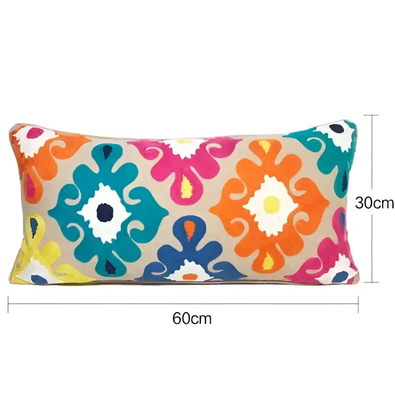 Vibrant rectangular pillow cover with embroidered floral ikat pattern in orange teal pink yellow and ethnic tassels