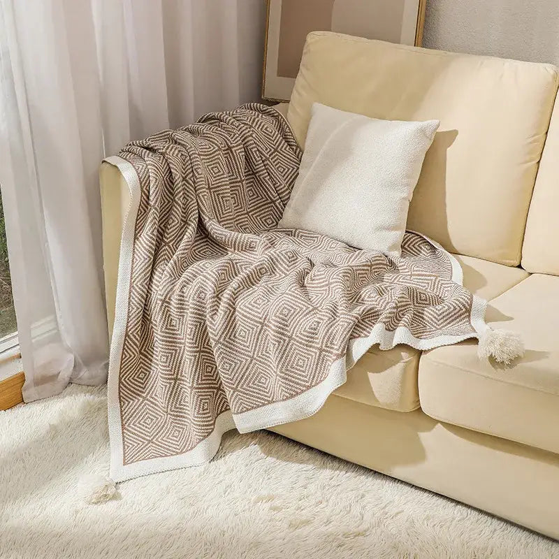 Beige and cream ethnic geometry knitted blanket with soft textured knit fabric and white pom-pom trim for sofa decorbites ethnic geometry