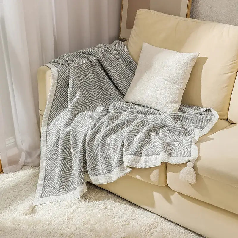 Gray and white ethnic geometry knitted throw blanket with soft textured weave and tassel trim for living room decorbites