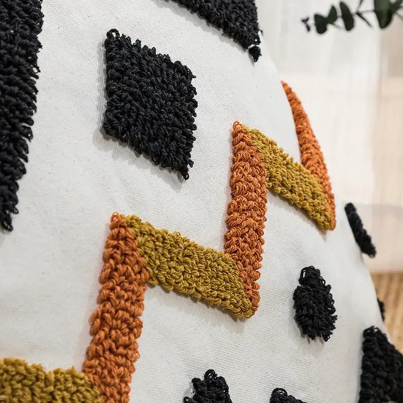 White cushion cover with chunky black orange and mustard yellow crochet pattern decorbites ethnic style black geometric decor
