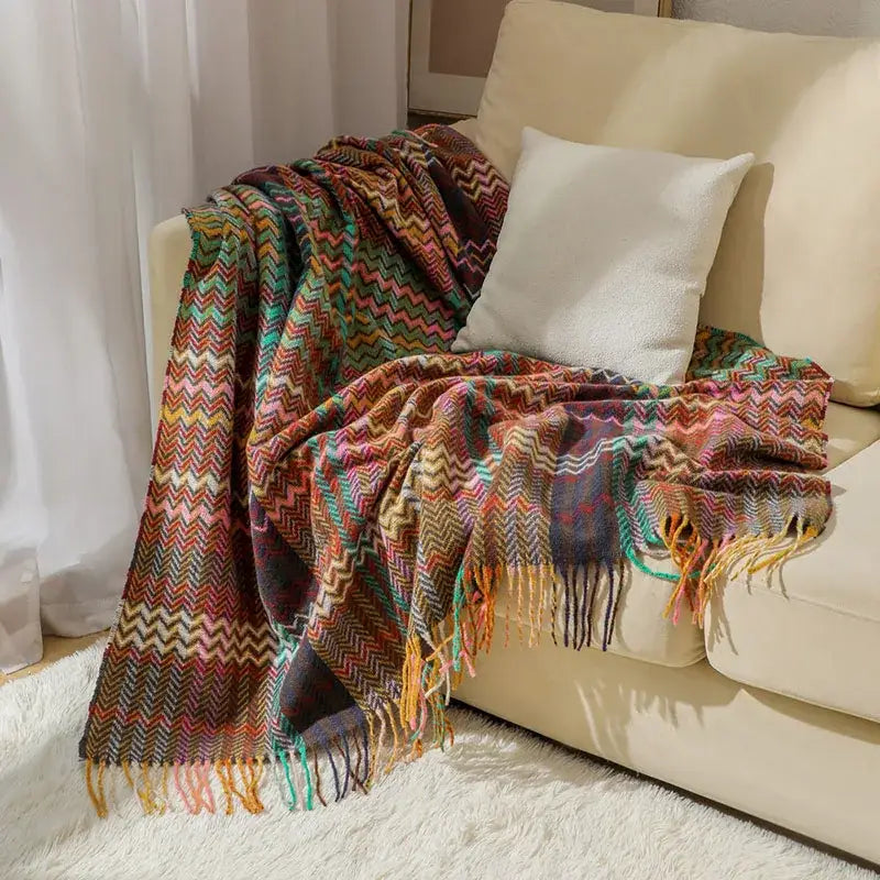 Ethnic wave woven multicolored zigzag throw blanket with tassels draped over beige sofa for bedroom decorbites ethnic wave
