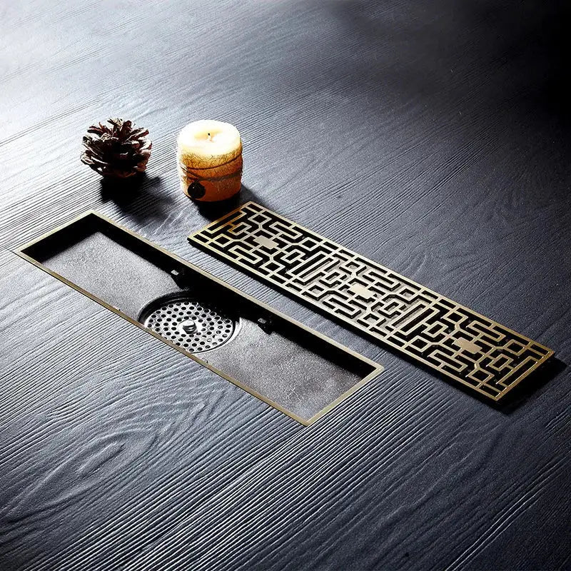 Bronze-colored euro antique brass floor drain with intricate geometric lattice and central perforated grate for bathroom shower waste