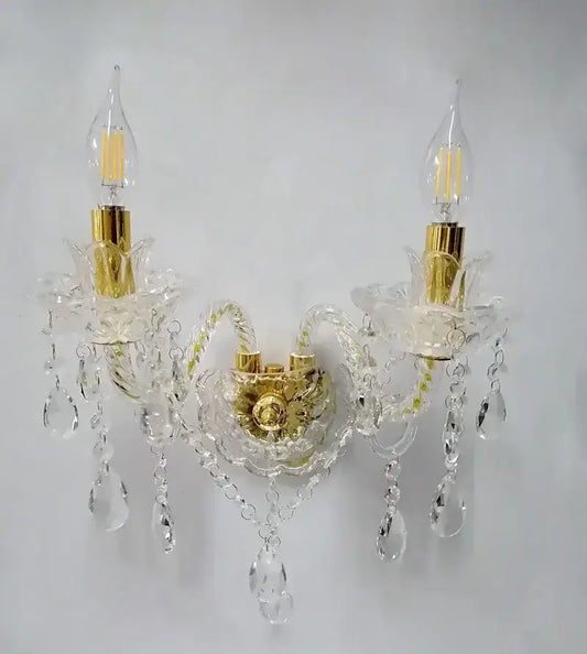 European gold crystal wall lamp with candle-style bulbs and dangling teardrop crystals for bedroom use