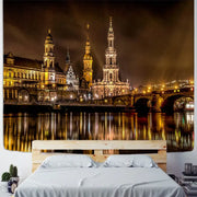 A rectangular European style tapestry featuring a vibrant city night scene with golden spires and bridges reflected in water