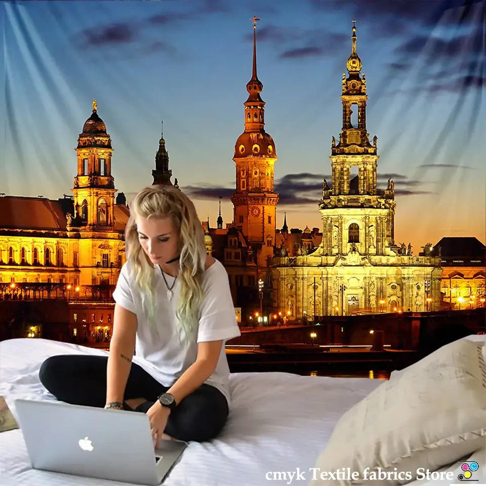 Silver apple laptop with sleek minimalist design and matte finish placed beside european style city night scene tapestry