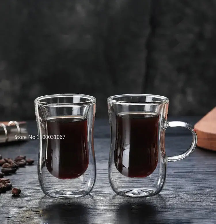 European style clear double glass insulated tea cups with handles filled with dark liquid for kitchenware use