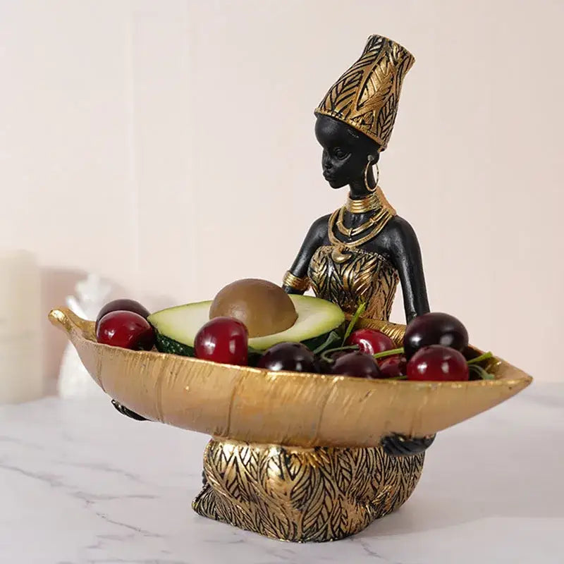 Black african woman resin figurine holding a golden bowl of fruit for exotic living room decor in black and gold