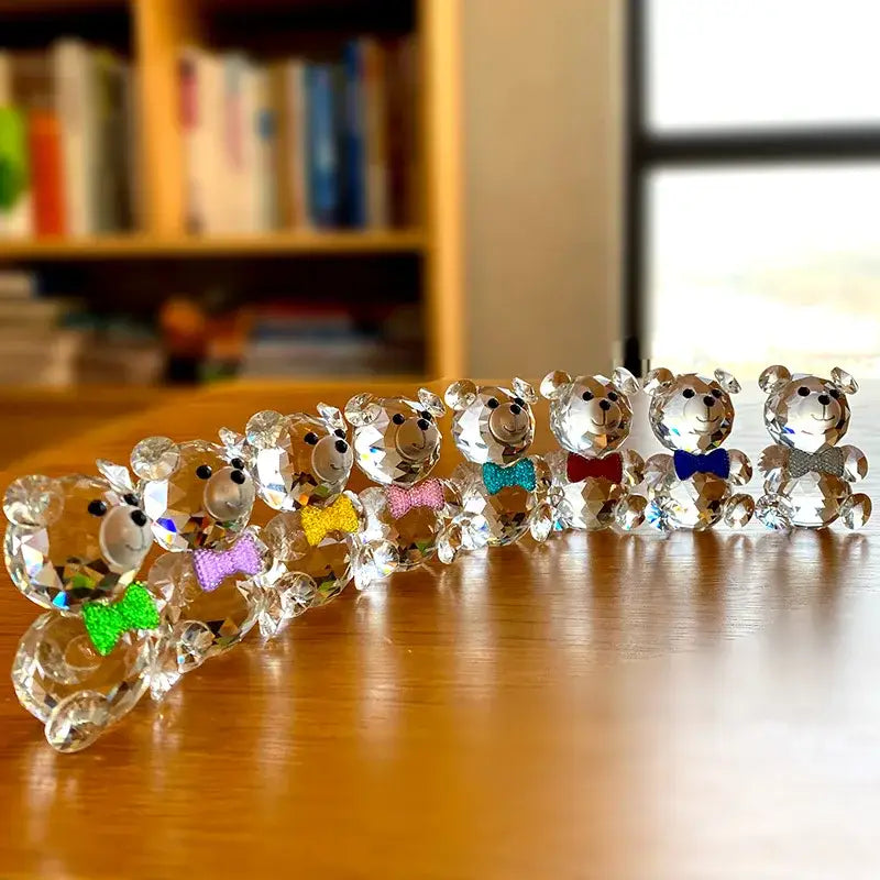 A row of faceted clear crystal teddy bear figurines with colorful bow ties for elegant bedroom decor