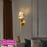 Faceted crystal gold led wall sconce with a gold-toned metal base and crystal-like lampshade for bedroom decorbites wall sconce