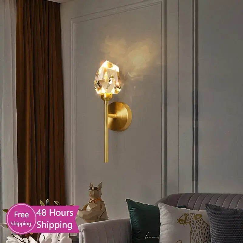 Faceted crystal gold led wall sconce with a gold-toned metal base and crystal-like lampshade for bedroom decorbites wall sconce