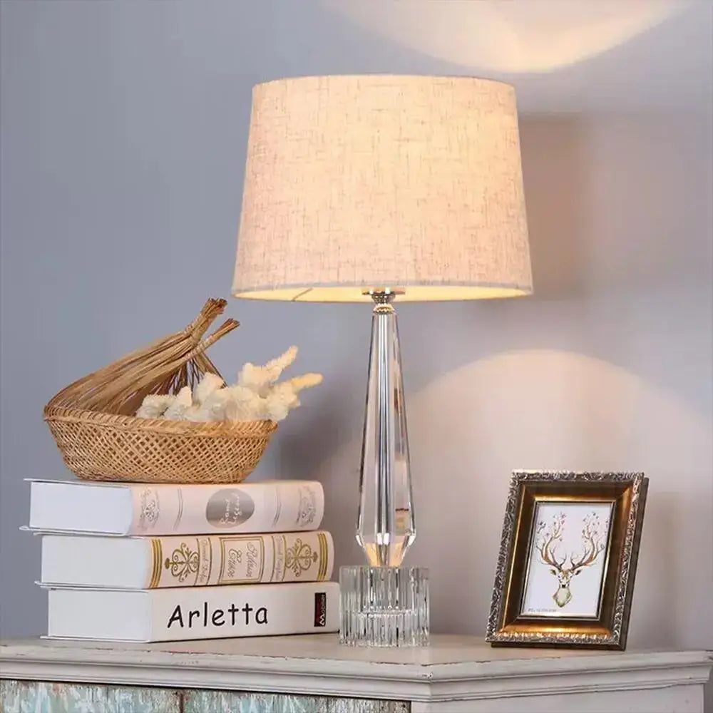 Faceted crystal table lamp with a clear crystal base and beige fabric shade for elegant bedroom decorbites crystal table use