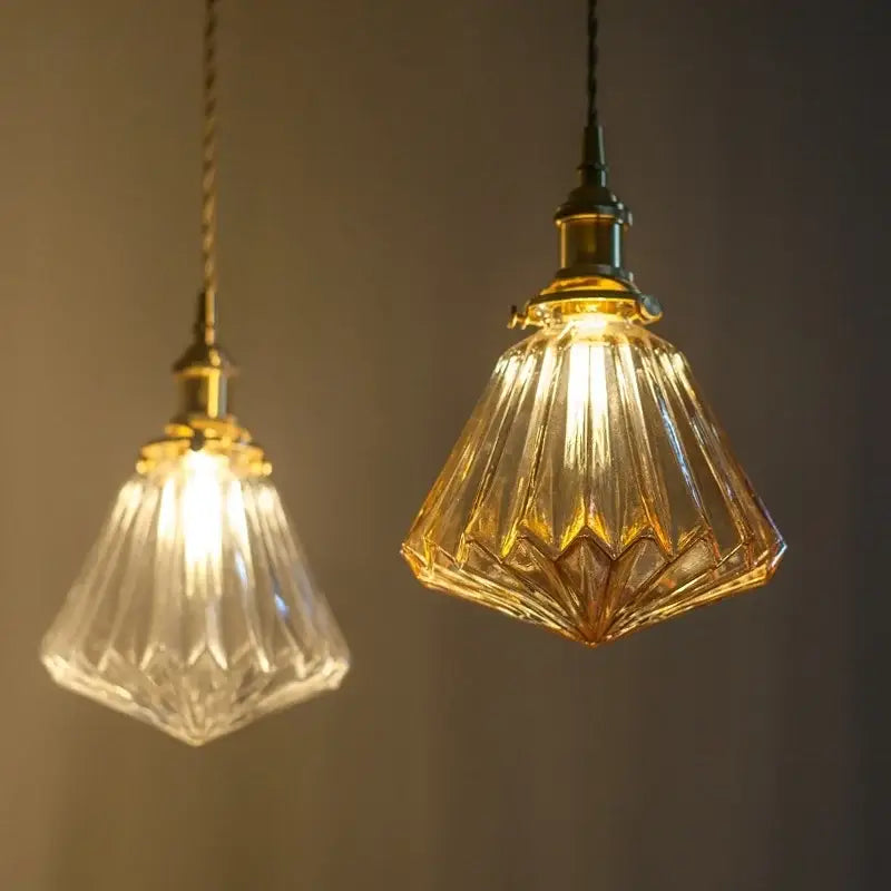 Two vintage-style pleats led pendant lights with clear and amber faceted glass shades and brass fixtures for dining room
