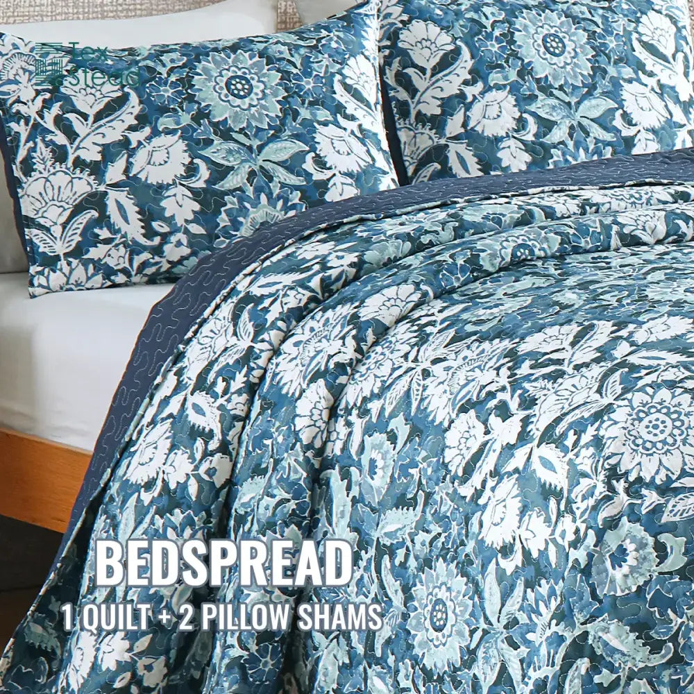 Farmhouse blue and white floral quilted bedding set featuring a blue floral quilted bedspread with white botanical patterns