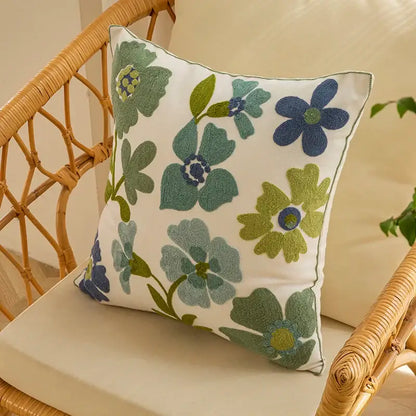 A square white pillow cover with embroidered green and blue flowers and subtle stitched border for farmhouse decorbites decorative farmhouse throw
