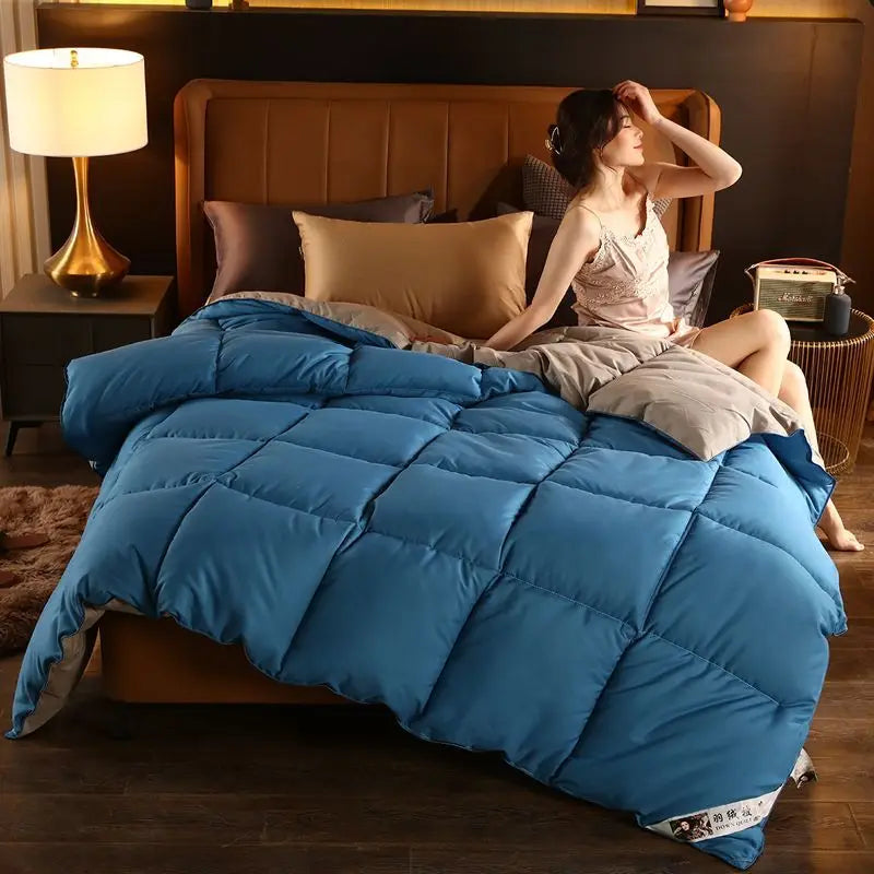 A plush vibrant blue quilted comforter with stitched square panels made of high-quality white goose down filling
