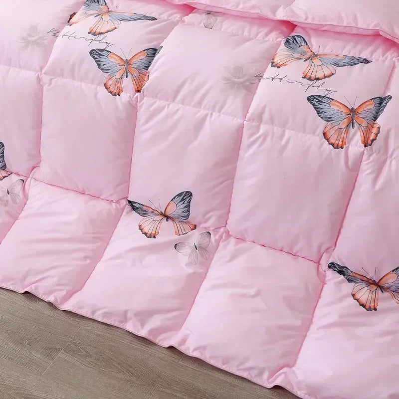 Pink quilted comforter with colorful butterfly pattern made of white goose down for comfortable winter bedding
