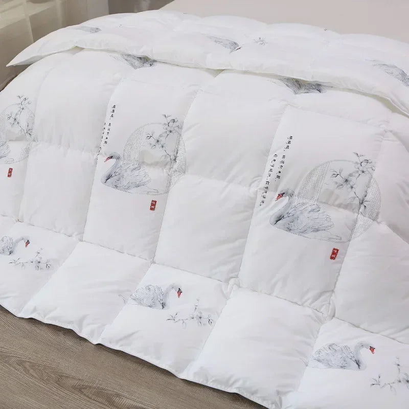 White goose down quilt in white with embroidered swans and floral motifs in soft gray tones accented by red seals