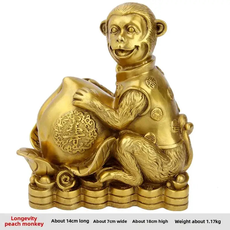 Golden brass copper monkey figurine holding a peach seated on stacked coins for feng shui wealth decor