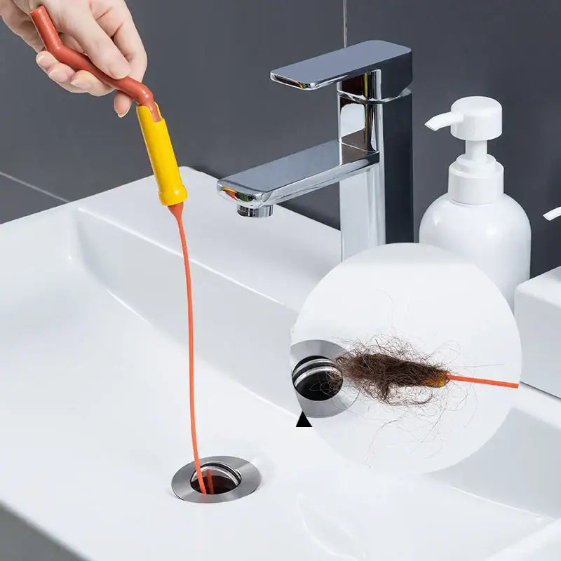 Flexible orange and yellow drain cleaner brush with a long thin cord for kitchen clog removal