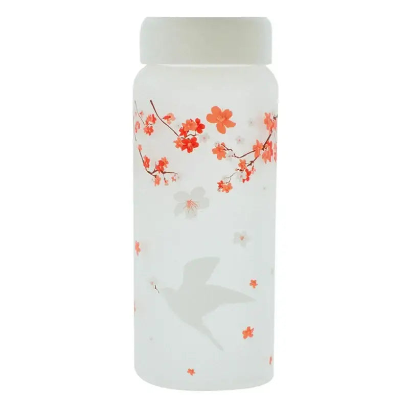 A frosted white glass water bottle with an orange cherry blossom pattern and gray dove silhouette for kitchen use