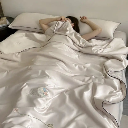 Cream-colored satin duvet cover with delicate embroidered floral and chain design in summer blanket set
