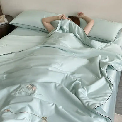 A soft mint green satin summer blanket set with delicate embroidery and black piping for elegant bedroom bedding