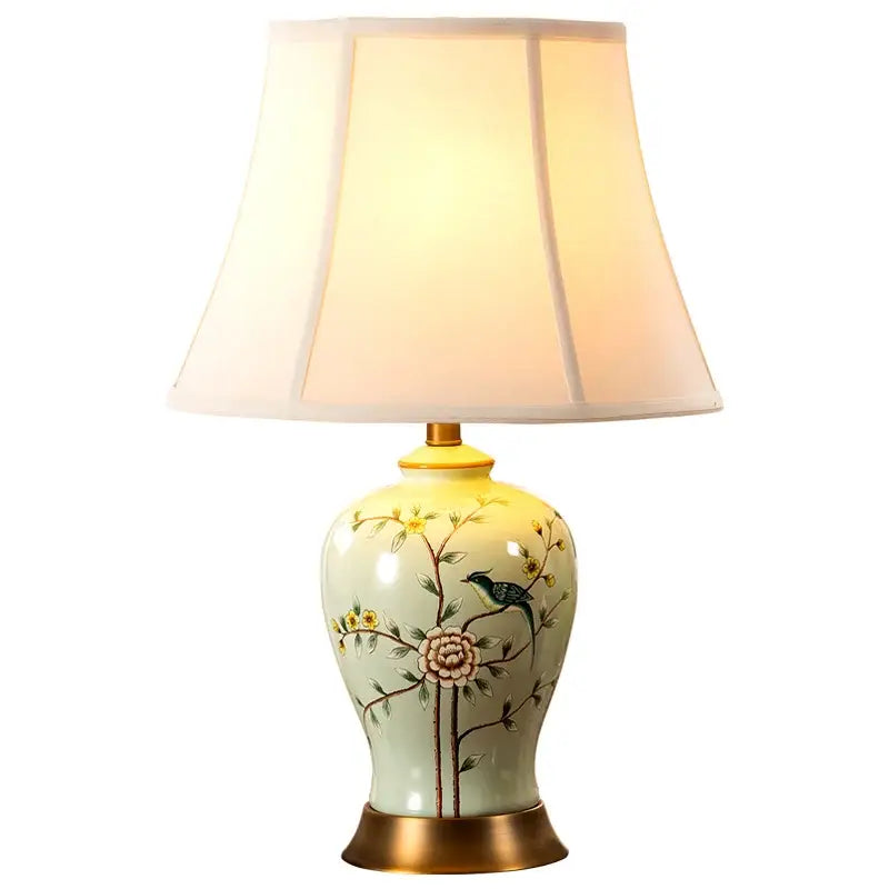 A delicate pale green ceramic vase table lamp with hand-painted floral bird motifs and cream fabric shade for living room decorbites decor