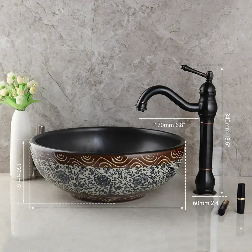 Floral black ceramics sink with intricate white floral and brown wavy patterns paired with a brass faucet bathroom basin set