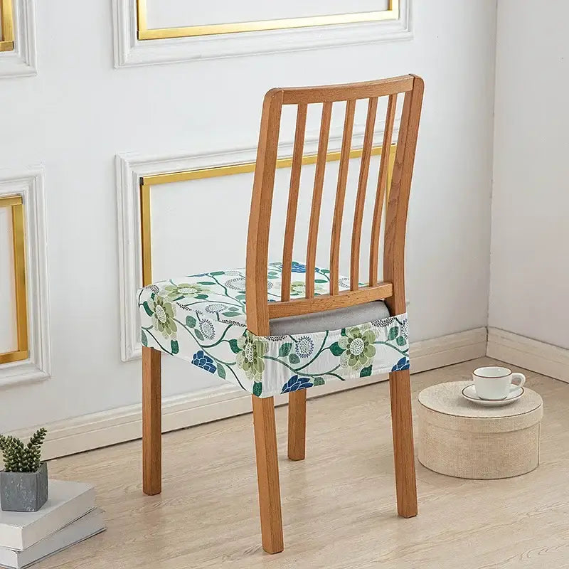 Floral blue and green elastic print chair cover made of stretchy fabric fitting snugly over a wooden dining chair