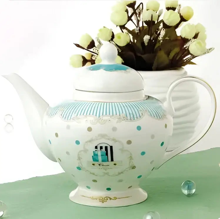 A delicate white porcelain bone china tea set teapot with turquoise polka dots and gold trimmed arched window design